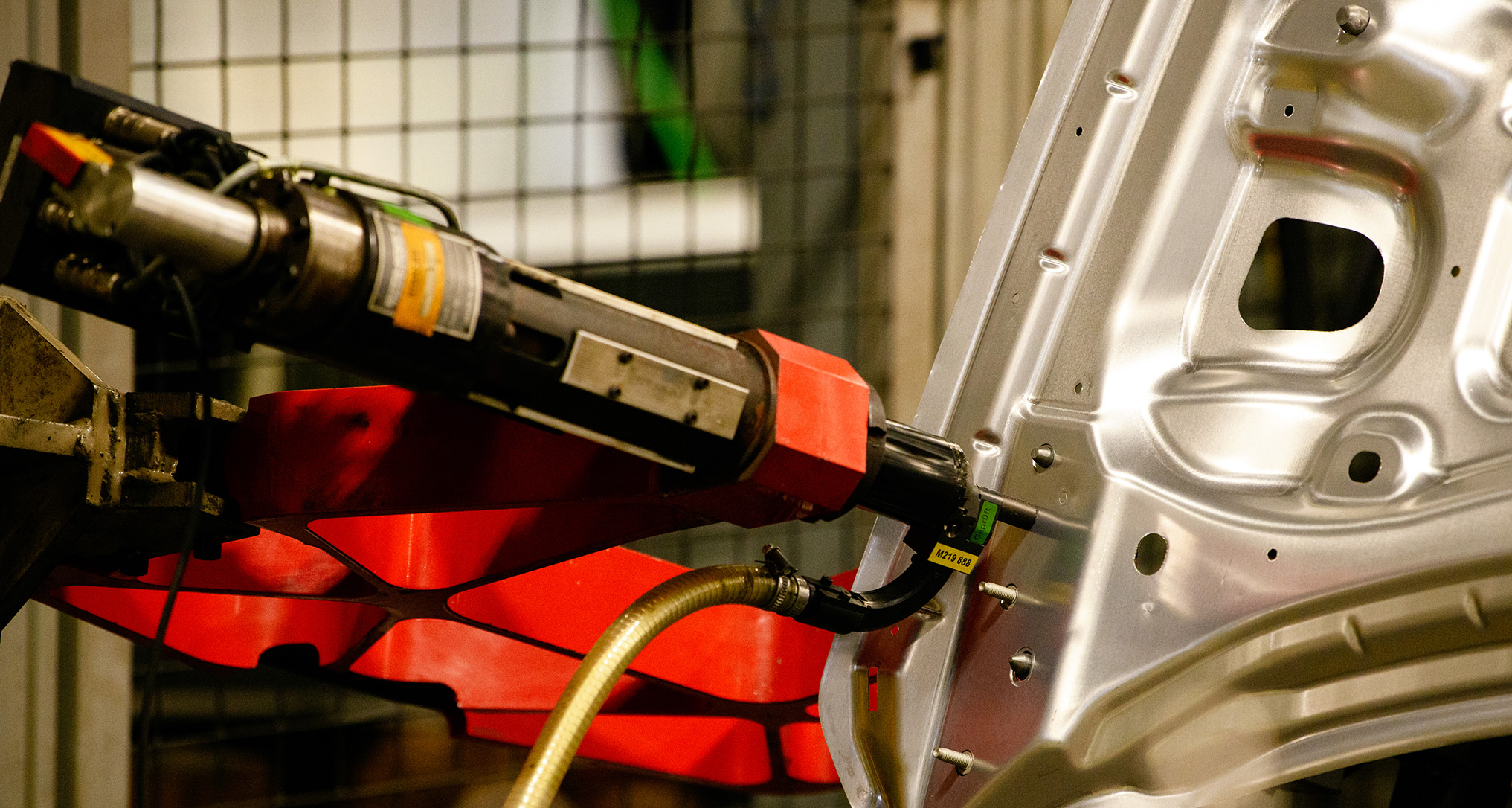 Robotic welding machine working on sheet of silver metal