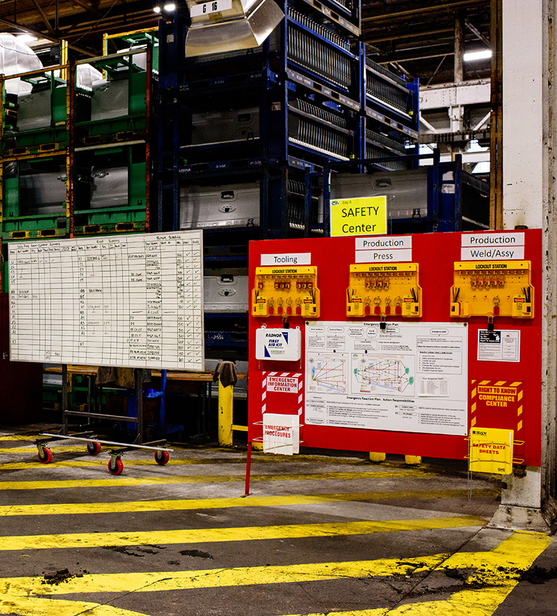 Whiteboard on the left with multiple columns and rows with checks and various notes. On the right, a large red board with the title Safety Center.